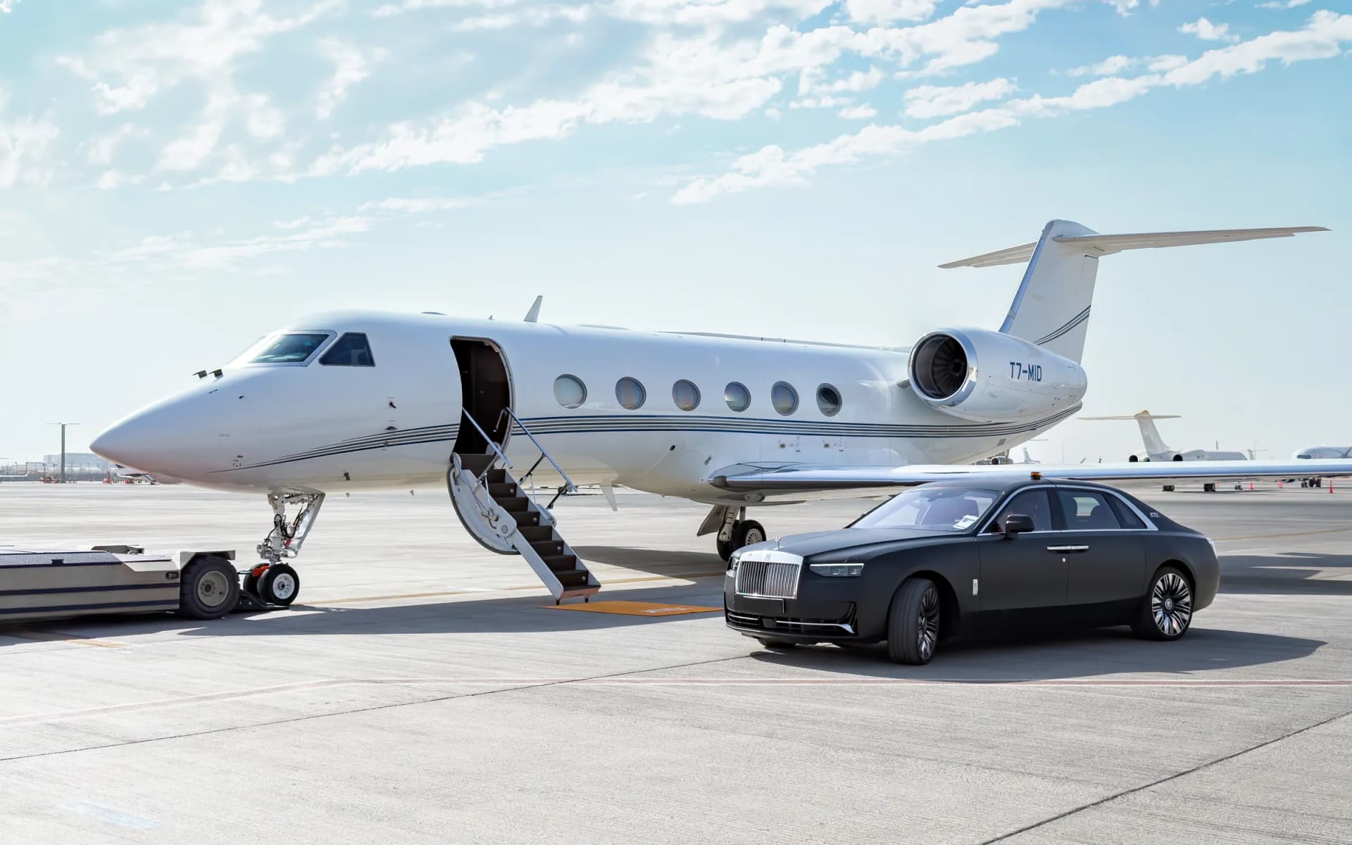 Gulfstream G450 T7-MID on the Dubai ramp with its airstair down beside a waiting Rolls-Royce