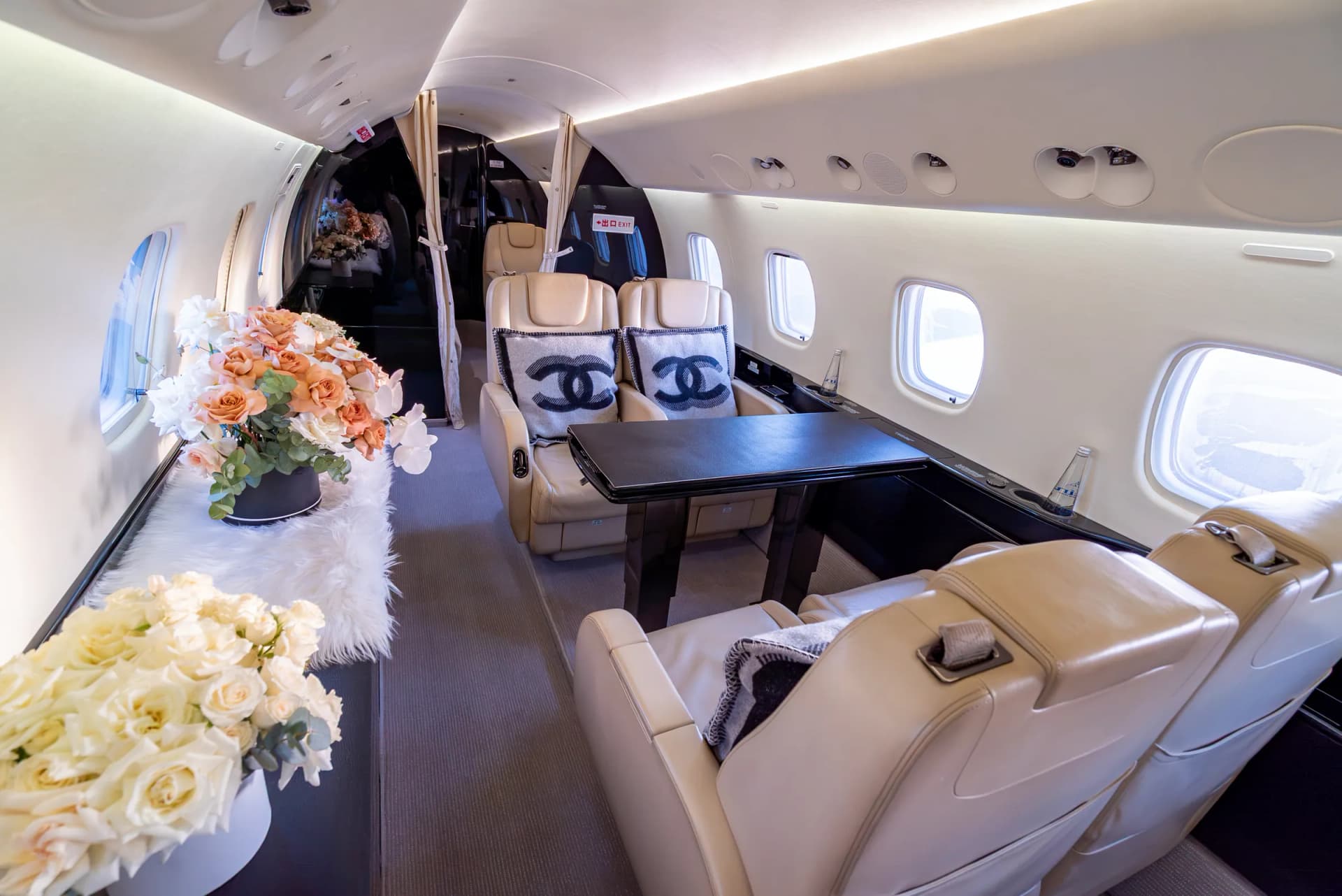 The Embraer Legacy 650 conference table with white and peach flowers along the credenza